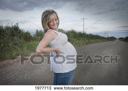 a pregnant woman stands on a dirt road; edmonton alberta canada View Large Photo Image Stock Image - a pregnant woman stands on a dirt road; edmonton alberta canada. Fotosearch