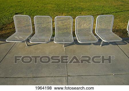 Stock Photo - a row of silver chairs on the cement and grass; san francisco, california, united states of america. Fotosearch