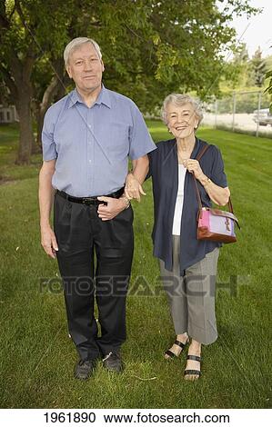 a senior couple standing and holding hands; edmonton, alberta, canada View Large Photo Image Stock Image - a senior couple standing and holding hands; edmonton, alberta, canada. Fotosearch