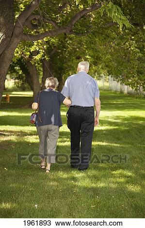 a senior couple walking together across the grass; edmonton, alberta, canada View Large Photo Image Stock Image - a senior couple walking together across the grass; edmonton, alberta, canada. Fotosearch