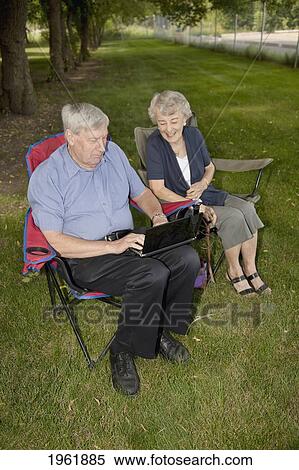 a senior man and woman sitting together using a laptop computer; edmonton, alberta, canada View Large Photo Image Stock Photography - a senior man and woman sitting together using a laptop computer; edmonton, alberta, canada. Fotosearch