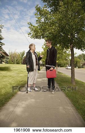 a senior woman talks with a teenage boy; edmonton, alberta, canada View Large Photo Image Stock Photo - a senior woman talks with a teenage boy; edmonton, alberta, canada. Fotosearch