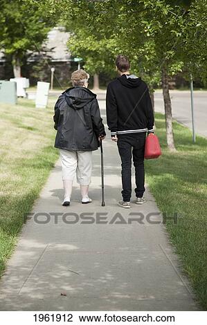 a senior woman walks and talks with a teenage boy; edmonton, alberta, canada View Large Photo Image Stock Image - a senior woman walks and talks with a teenage boy; edmonton, alberta, canada. Fotosearch