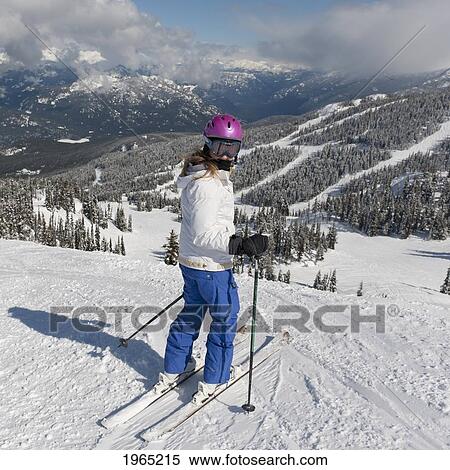 Stock Photography - a skier on a ski trail with forests and mountains in the background; whistler british columbia canada. Fotosearch
