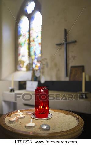 Stock Image - a table with candles at an altar in a church; northumberland england. Fotosearch