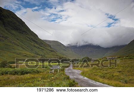 Stock Photograph - a wet country road in a valley; kingairloch argyl scotland. Fotosearch