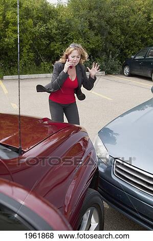 a woman makes a phone call for help after she gets into a car accident; edmonton, alberta, canada View Large Photo Image Stock Photo - a woman makes a phone call for help after she gets into a car accident; edmonton, alberta, canada. Fotosearch