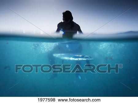 a woman sitting on a surfboard in the water; tarifa cadiz andalusia spain View Large Photo Image Stock Photo - a woman sitting on a surfboard in the water; tarifa cadiz andalusia spain. Fotosearch