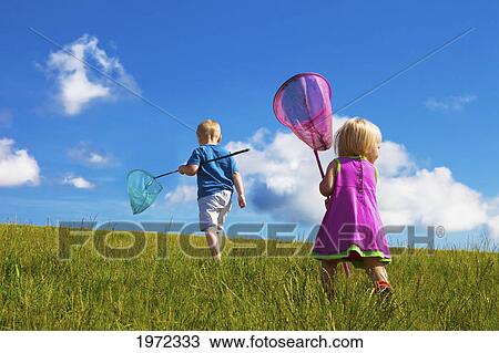 a young boy and girl walk through a field with butterfly catchers; stony plain alberta canada View Large Photo Image Stock Image - a young boy and girl walk through a field with butterfly catchers; stony plain alberta canada. Fotosearch