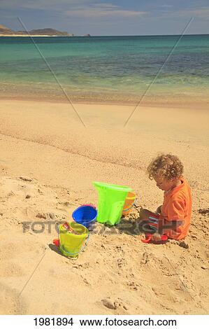 a young boy plays in the sand with his sand toys at cabo pulmo; baja california sur mexico View Large Photo Image Picture - a young boy plays in the sand with his sand toys at cabo pulmo; baja california sur mexico. Fotosearch