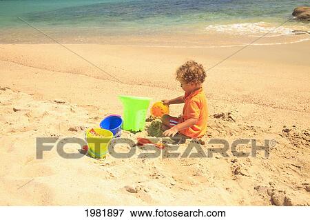 a young boy plays in the sand with his sand toys at cabo pulmo; baja california sur mexico View Large Photo Image Stock Photo - a young boy plays in the sand with his sand toys at cabo pulmo; baja california sur mexico. Fotosearch
