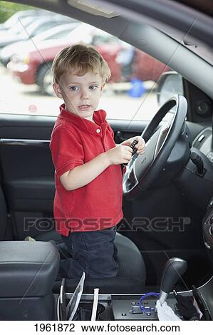 a young boy sits by the steering wheel in the front seat of a car; edmonton, alberta, canada View Large Photo Image Stock Image - a young boy sits by the steering wheel in the front seat of a car; edmonton, alberta, canada. Fotosearch