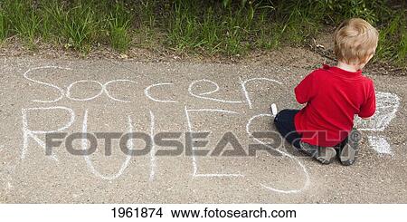 a young boy sits on the concrete with a written message in chalk saying soccer rules; edmonton, alberta, canada View Large Photo Image Picture - a young boy sits on the concrete with a written message in chalk saying soccer rules; edmonton, alberta, canada. Fotosearch