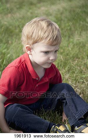 a young boy sits on the grass; edmonton, alberta, canada View Large Photo Image Stock Image - a young boy sits on the grass; edmonton, alberta, canada. Fotosearch