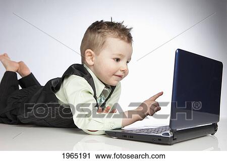 Stock Image - a young boy uses a laptop computer; edmonton alberta canada. Fotosearch