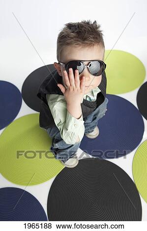 a young boy wearing sunglasses and standing on coloured dots on the floor; edmonton alberta canada View Large Photo Image Stock Photo - a young boy wearing sunglasses and standing on coloured dots on the floor; edmonton alberta canada. Fotosearch