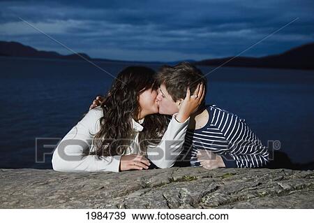 a young couple kissing on the shoreline at dusk; bellingham washington united states of america View Large Photo Image Stock Photo - a young couple kissing on the shoreline at dusk; bellingham washington united states of america. Fotosearch