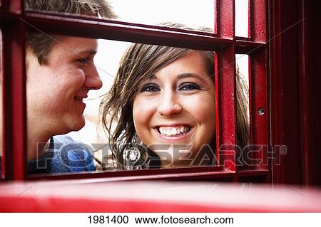 a young couple smiling through a red english phone booth; bellingham washington united states of america View Large Photo Image Stock Image - a young couple smiling through a red english phone booth; bellingham washington united states of america. Fotosearch