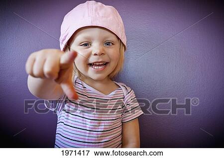 Stock Photo - a young girl points at the camera; spruce grove alberta canada. Fotosearch