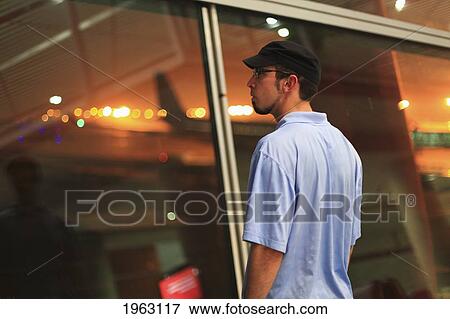 a young man gazing out a window at the beijing airport; beijing, china View Large Photo Image Stock Photo - a young man gazing out a window at the beijing airport; beijing, china. Fotosearch