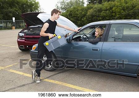 a young man helps a woman with car trouble; edmonton, alberta, canada View Large Photo Image Stock Image - a young man helps a woman with car trouble; edmonton, alberta, canada. Fotosearch