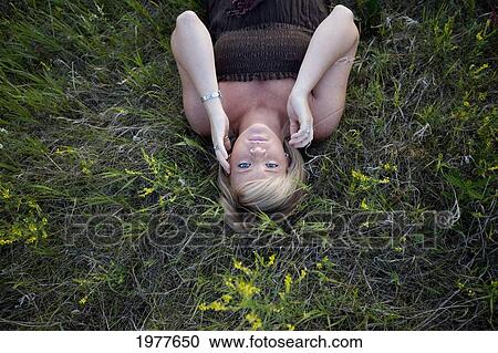 a young woman lays on her back on the grass; edmonton alberta canada View Large Photo Image Stock Image - a young woman lays on her back on the grass; edmonton alberta canada. Fotosearch