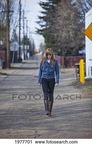 a young woman walking alone down an alley; edmonton alberta canada View Large Photo Image Stock Image - a young woman walking alone down an alley; edmonton alberta canada. Fotosearch