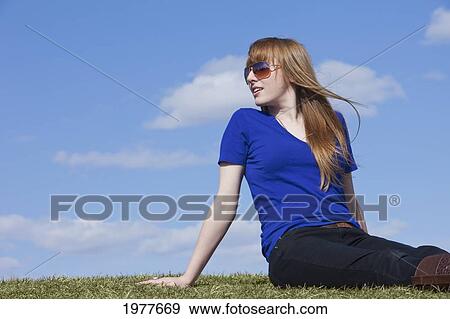 a young woman wearing sunglasses sits on the grass; edmonton alberta canada View Large Photo Image Stock Photo - a young woman wearing sunglasses sits on the grass; edmonton alberta canada. Fotosearch