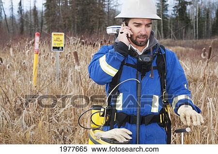 an inspector talking on the phone while inspecting pipelines; whitecourt alberta canada View Large Photo Image Stock Photography - an inspector talking on the phone while inspecting pipelines; whitecourt alberta canada. Fotosearch