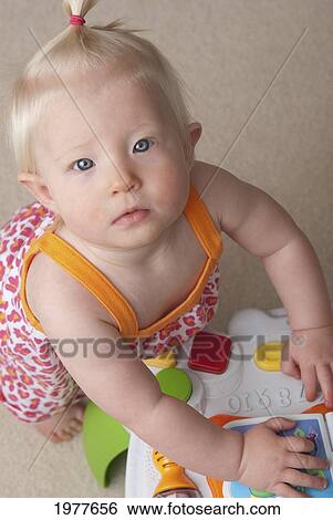 Stock Photograph - baby girl playing; millet alberta canada. Fotosearch