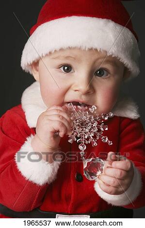 baby in a santa claus outfit chewing on an ornament; edmonton alberta canada View Large Photo Image Stock Photo - baby in a santa claus outfit chewing on an ornament; edmonton alberta canada. Fotosearch