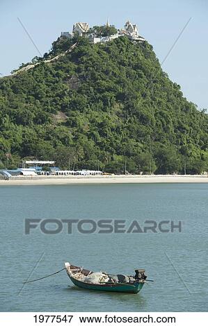Stock Photo - boat on water and a hill in the background; prachuap kiri khan prachuap province thailand. Fotosearch
