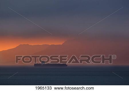 cargo ship passing through straits of gilbraltar at dawn with the coastline of morocco in the background; tarifa cadiz andalusia spain View Large Photo Image Stock Image - cargo ship passing through straits of gilbraltar at dawn with the coastline of morocco in the background; tarifa cadiz andalusia spain. Fotosearch