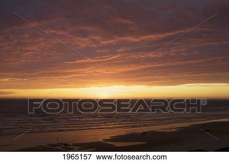 dramatic clouds at sunset on a beach with the light reflecting in the ocean; lincoln city oregon united states of america View Large Photo Image Stock Photo - dramatic clouds at sunset on a beach with the light reflecting in the ocean; lincoln city oregon united states of america. Fotosearch
