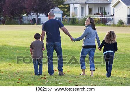 family walking together in a park and mother smiling; beaumont alberta canada View Large Photo Image Stock Photo - family walking together in a park and mother smiling; beaumont alberta canada. Fotosearch