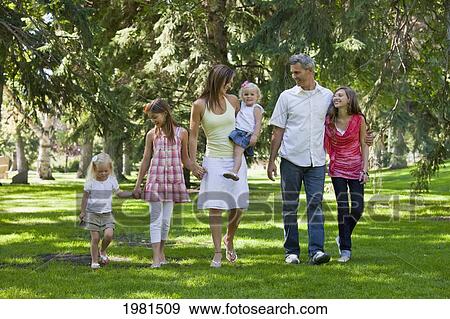 Stock Photo - family walking together in a park; edmonton alberta canada. Fotosearch