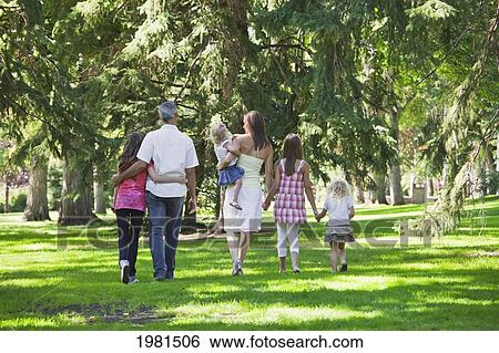 Stock Photograph - family walking together in a park; edmonton alberta canada. Fotosearch