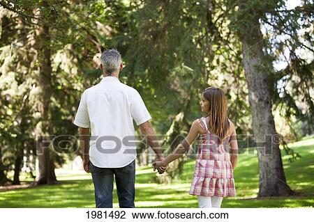 father and daughter holding hands walking in the park; edmonton alberta canada View Large Photo Image Stock Image - father and daughter holding hands walking in the park; edmonton alberta canada. Fotosearch