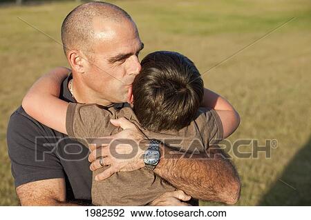 father embracing his son in a park; beaumont alberta canada View Large Photo Image Stock Image - father embracing his son in a park; beaumont alberta canada. Fotosearch