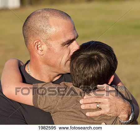 father embracing his son in a park; beaumont alberta canada View Large Photo Image Stock Photography - father embracing his son in a park; beaumont alberta canada. Fotosearch