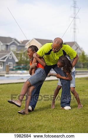 father wrestling with daughters; edmonton alberta canada View Large Photo Image Picture - father wrestling with daughters; edmonton alberta canada. Fotosearch