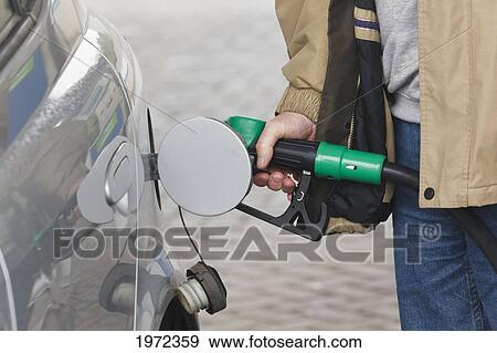 man pumping petrol into car; dunmanway county cork ireland View Large Photo Image Stock Photo - man pumping petrol into car; dunmanway county cork ireland. Fotosearch