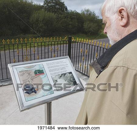 man reading information plaque at roadside memorial of ambush site where michael collins was killed on august 22 1922; beal na blath county cork ireland View Large Photo Image Picture - man reading information plaque at roadside memorial of ambush site where michael collins was killed on august 22 1922; beal na blath county cork ireland. Fotosearch