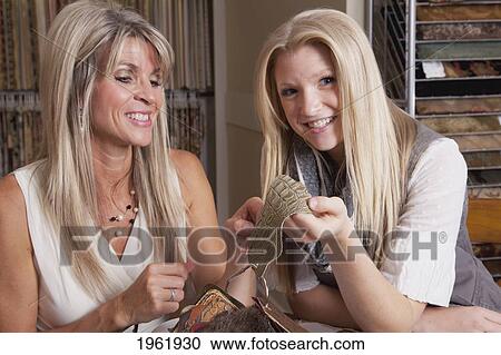 Stock Image - mother and daughter discussing colours and samples for remodelling of home; edmonton, alberta, canada. Fotosearch