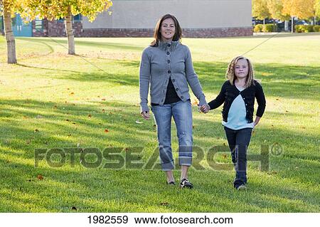 mother and daughter walking in a park by the school; beaumont alberta canada View Large Photo Image Stock Photo - mother and daughter walking in a park by the school; beaumont alberta canada. Fotosearch