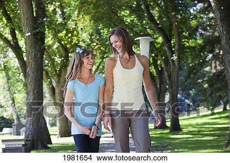 Picture - mother and daughter walking in park together; edmonton alberta canada. Fotosearch