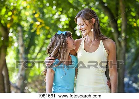 Stock Image - mother and daughter walking together in the park; edmonton alberta canada. Fotosearch