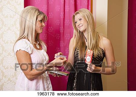 mother buying daughter a dress at a boutique; edmonton, alberta, canada View Large Photo Image Stock Photo - mother buying daughter a dress at a boutique; edmonton, alberta, canada. Fotosearch