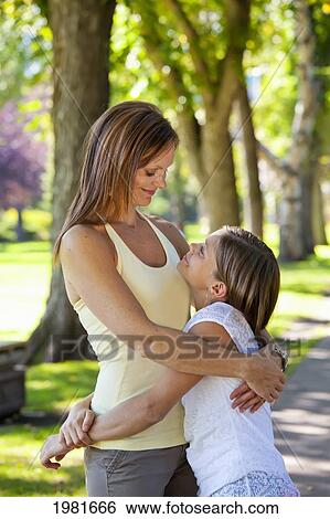 mother embracing daughter in the park; edmonton alberta canada View Large Photo Image Stock Photograph - mother embracing daughter in the park; edmonton alberta canada. Fotosearch