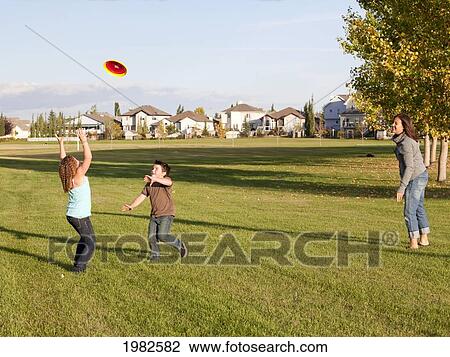 mother throwing flying disc to children in a park; beaumont alberta canada View Large Photo Image Stock Image - mother throwing flying disc to children in a park; beaumont alberta canada. Fotosearch
